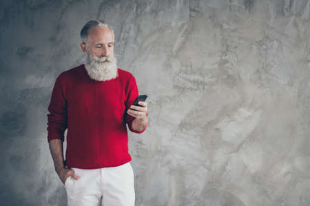 Portrait of masculine serious retired old man stand copyspace use smartphone read x-mas christmas...