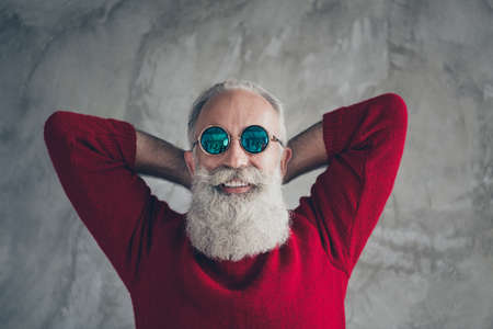 Top above high angle photo of positive dreamy old man relax dream enjoy christmas time x-mas wear modern pullover isolated over grey concrete wall color backgroundの写真素材