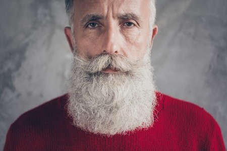 Closeup photo of serious aged business guy looking minded on camera wear red knitted pullover jumper cool hipster outfit isolated grey color concrete wall backgroundの写真素材