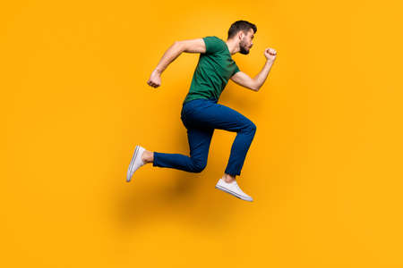 Full length profile side photo of serious focused guy jump run fast want buy spring black friday discounts wear casual style outfit isolated over yellow color background