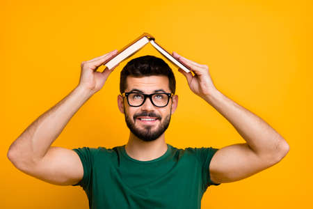 Close up photo of cheerful brunet hair guy put paper book above head look creative reading concept...