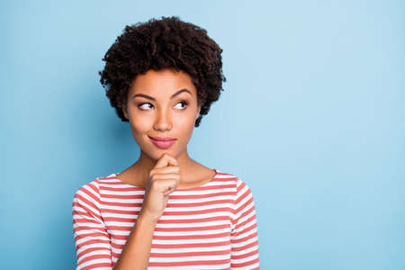 Photo of cheerful cute pretty sly girlfriend touching her chin trying to come up with curious creative idea looking into empty space isolated pastel blue color backgroundの写真素材