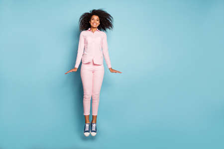 Full length photo of amazing dark skin lady jumping high weekend mood crazy person wear pink shirt...