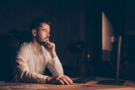 Photo side profile of serious pensive programmer working overtime, interested in solving bugs...