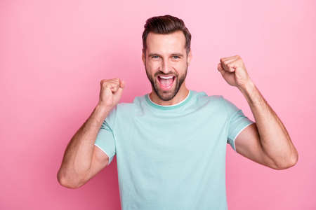 Portrait of delighted man win lottery raise fists shout yeah wear casual style outfit isolated over...