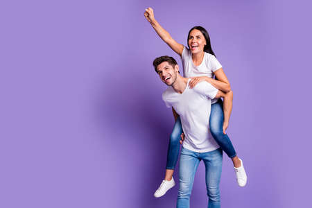 Photo of piggyback pretty cute couple in jeans denim white t-shirt with man carrying girl her...