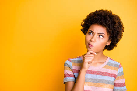 Photo of pensive concentrated focused girl contemplating empty space above her touching her chin...