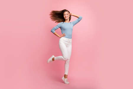 Full length body size photo of cheerful cute pretty beautiful attractive girl enjoying free holiday time in trousers blue sweater isolated pastel color backgroundの写真素材