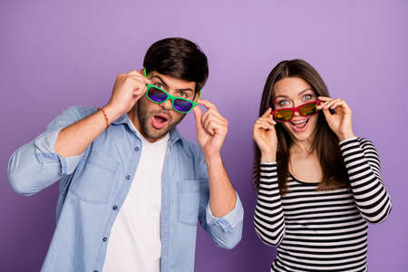 Photo of couple guy lady looking advert banner read announcement for black friday final season sales overjoyed wear sun specs casual outfit isolated purple color backgroundの写真素材