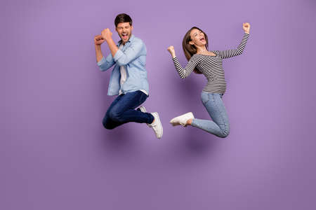 Full body photo of two people couple funny guy lady jumping high celebrating sportive competition...
