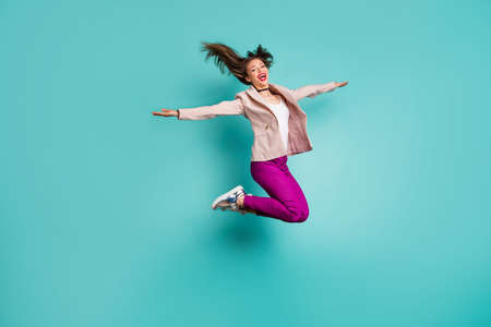Full length body size view of her she nice attractive careless cheerful cheery girl jumping having fun fooling flying isolated on bright vivid shine vibrant blue green turquoise color backgroundの写真素材
