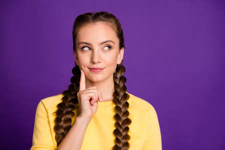Photo of tricky mood lady long braids hairdo hold arm on chin looking cunning empty space have crazy...