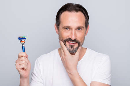 Closeup photo of handsome mature handsome man looking mirror use razor going to shave beard...