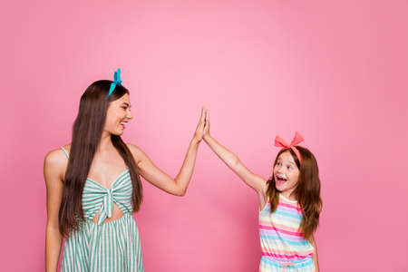 Profile side photo of cheerful siblings giving high five screaming wearing bright headbands dress...