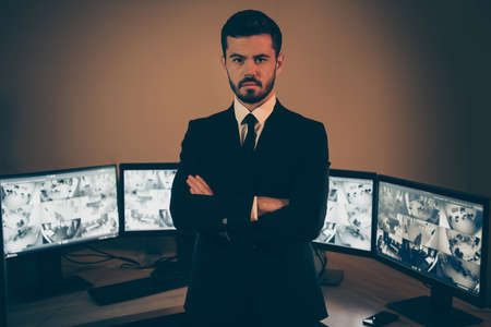 Portrait of his he nice attractive stylish trendy imposing experienced serious man safety expert supervising panel night shift folded arms at work station placeの写真素材