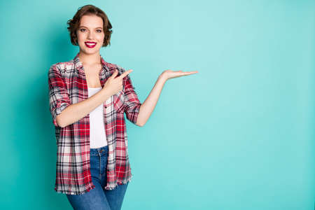 Portrait positive cheerful girl point index finger hold hand indicate ads promo recommend choose...