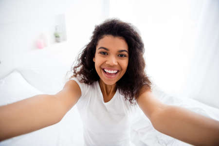 Closeup photo of pretty funny curly dark skin lady in bedroom making selfies good morning weekend...