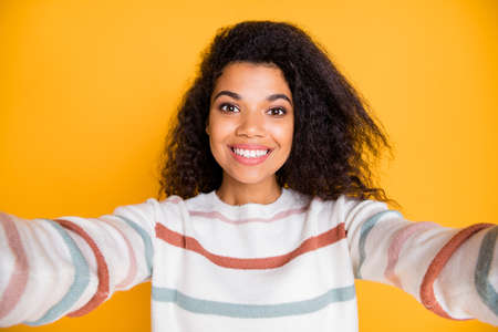 Hello to all followers. Close up portrait of attractive beauty with kind appearance hipster making selfie on modern device wearing casual outfit isolated bright color backgroundの写真素材