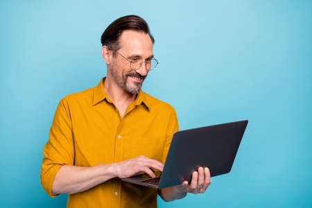Portrait of positive man worker work on his computer text with his family colleagues wear yellow...