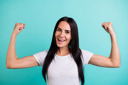 Close-up portrait of nice attractive cheerful straight-haired girl showing muscles motivation sportive life lifestyle isolated on bright vivid shine vibrant teal green blue turquoise color backgroundの写真素材