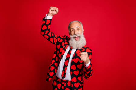 Photo of funky mature guy amour cupid character role raising fists excited party beginning wear stylish hearts pattern suit costume shirt tie isolated vivid color backgroundの写真素材