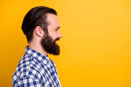 Close-up profile side view portrait of his he nice attractive cheerful bearded guy wearing checked shirt modern haircut copy space isolated over bright vivid shine vibrant yellow color backgroundの写真素材