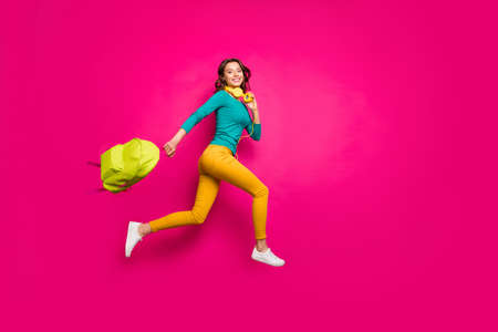 Full length body size side profile photo of cheerful positive nice pretty cute youngster wearing yellow pants trousers smiling toothily isolated pink vibrant color backgroundの写真素材