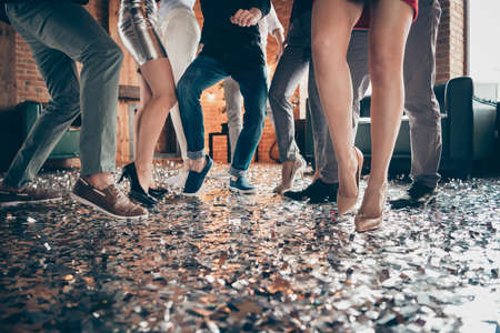 Cropped closeup photo of guys and girls perfect legs rejoicing dance floor x-mas party glitter flying air wear formalwear high-heels dress silver skirt pants restaurant indoorsの写真素材