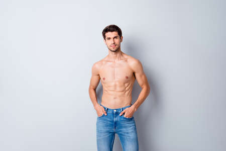 Portrait of his he nice attractive content cool fashionable muscular shirtless guy perfect figure form shape wearing jeans isolated over light white gray color pastel backgroundの写真素材