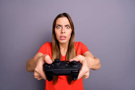 Portrait of impressed worried girl play video game dont want lose feel focused wear good looking clothing isolated over grey color backgroundの写真素材