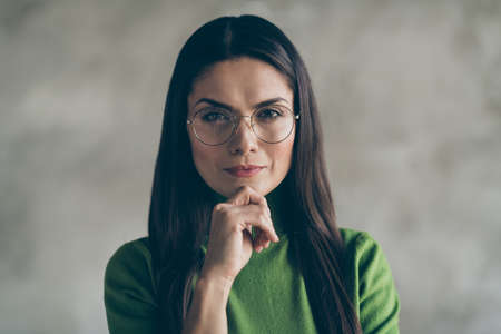 Close up photo of serious confident clever woman touching her chin with hand wearing spectacles eye...