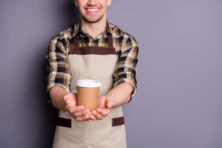 Cropped close up photo of cheerful positive handsome waiter serving you coffee cup as ordered isolated grey color backgroundの写真素材