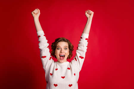 Portrait of positive cheerful girlfriend support sport championship win astonished impressed raise fists scream yeah wear good look jumper isolated over bright color backgroundの写真素材