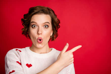 Close-up portrait of her she nice attractive amazed wondered cheerful cheery girl showing incredible copy space ad advert isolated over bright vivid shine vibrant red color backgroundの写真素材