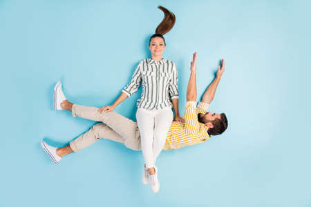 Top view above high angle flat lay flatlay lie concept view of his he her she nice cheerful funky spouses flying having fun time isolated on bright vivid shine vibrant blue turquoise color backgroundの写真素材