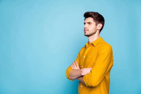 Photo of straight strict serious man standing with hands folded looking over empty space searching...
