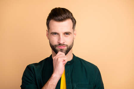 Closeup photo of handsome guy holding hand on chin deep thinking unsure startup idea is ready for presentation corporate meeting wear casual outfit isolated beige color backgroundの写真素材
