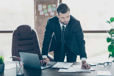 Photo of handsome business guy hold hand on notebook keyboard check paper contract details online...