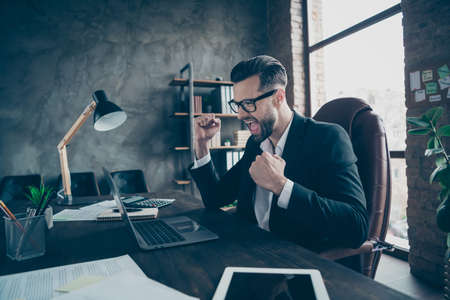 Profile photo of handsome business guy holding hands fists raised, celebrating success of new...