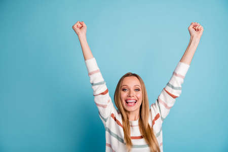 Photo of cheerful positive rejoicing woman raising her hands smiling toothily screaming with victory...