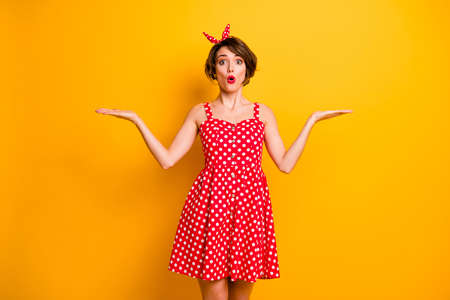 Portrait of astonished girl hold hand demonstrate incredible ads promotion impressed scream wow omg choose choice decide decision wear polka-dot skirt isolated over bright color backgroundの写真素材