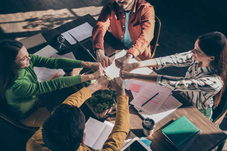 Top above high angle view photo of cheerful people creating big united team to get through work difficulties together showing fistsの写真素材