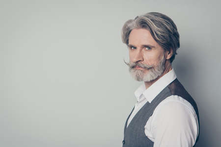 Closeup profile photo of aged handsome business man looking seriously not smiling perfect groomed hairdo bristle wear white shirt waistcoat isolated grey color backgroundの写真素材