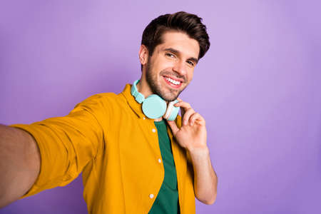 Self photo of stylish white cheerful man taking selfie expressing pleasure on face smiling toothily...