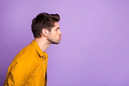 Side profile photo of serious man kissing empty space sending it to his beloved one with eyes closed isolated pastel color violet backgroundの写真素材