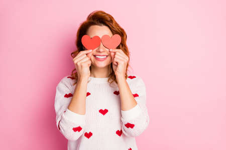 Close-up portrait of her she nice attractive cheerful cheery positive wavy-haired girl holding in hand small little heart closing eyes fooling isolated on pink pastel color backgroundの写真素材