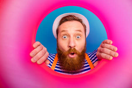 Close up photo astonished funky crazy man lifeguard look pink float lifebuoy impressed scream wow omg wear style stylish trendy white vest orange suspenders isolated blue color backgroundの写真素材