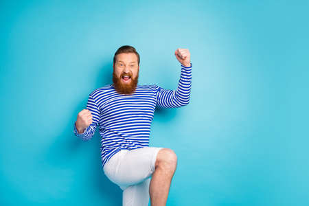 Portrait of delighted cheerful positive man celebrate lottery victory raise fists scream yeah wear...