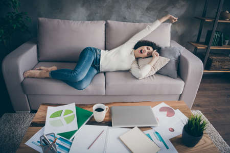Nice attractive lovely sleepy peaceful wavy-haired girl lying on divan having rest waking up...