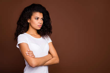 Turned photo of serious concentrated afro american girl cross hands ready decide decisions solution wear good looking outfit isolated over brown color backgroundの写真素材